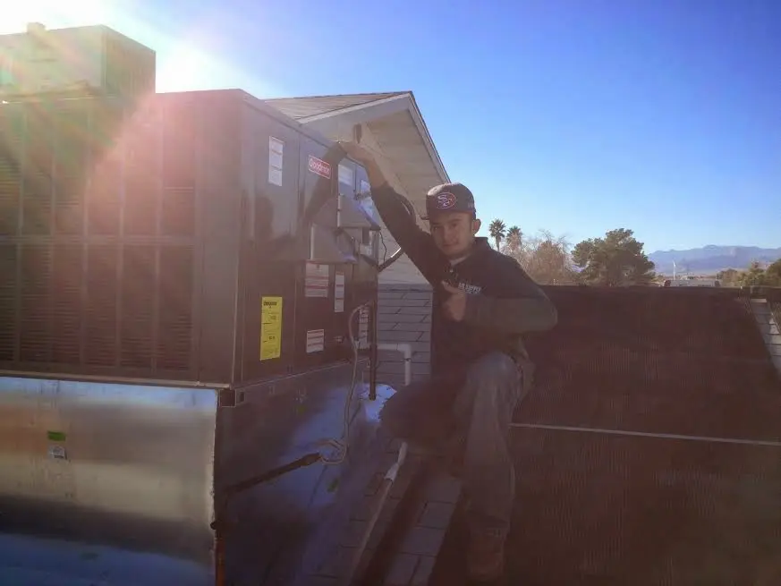 HVAC technician performing Boiler Repair on a rooftop unit in New Carrollton